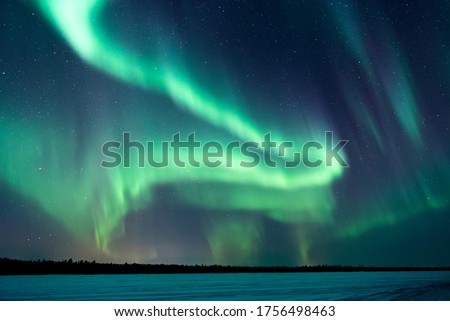 Northern lights, aurora borealis in the night sky over frozen lake in Lapland, Finland Royalty-Free Stock Photo #1756498463