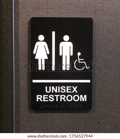 Unisex restroom sign on the wall outside a shared toilet 