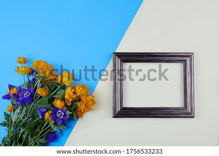 Bouquet of yellow globeflower, trollius europaeus and bluebell flower with frame for foto or blank card for text. Top view.