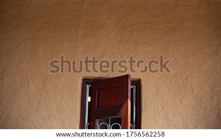 Structure of clay house and wooden windows, mud background. Soil Wall texture. Selective focus