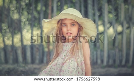 Portrait of a beautiful baby girl in a hat on nature