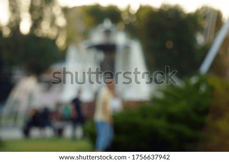 Blurred background. Fountain with people in the city Park. Outdoor activity.