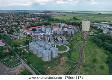 Aerial view with drone, an industrial area of ​​an agricultural town next to a railway network. Industrial elevator dryers, building exterior, storage and drying of cereals, wheat, corn, soybeans.