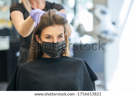 Adult woman at hairdresser wearing protective mask due to coronavirus pandemic Royalty-Free Stock Photo #1756653821