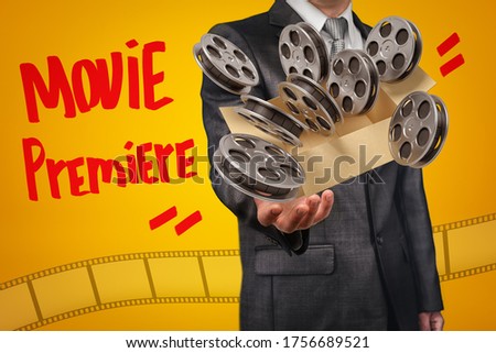 Anonymous businessman levitating box full of film reels that are flying out of the box on amber background with title 'Movie Premiere'. First night. Box office hits. Movie theater equipment.