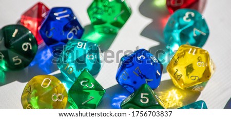 Assortment of colorful dice, sets of bright glittering happy-looking transparent RPG dice.