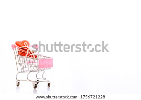 red heart shape in mini shopping cart in white background. love and shopping concept.