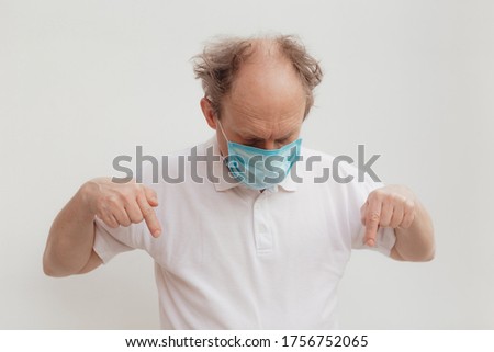 Stock Photo - Senior man in a white t-shirt wearing medical mask