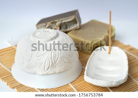 Handmade modeling air dry clay bowl and soap dish drying on a bamboo mat near two handmade soups Royalty-Free Stock Photo #1756753784