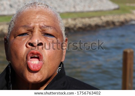 Women enjoying the outside telling her husband hold up before you take my picture with the lake in background 