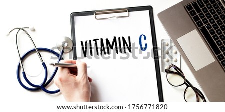 Doctor holding a card with Vitamin C, Medical concept