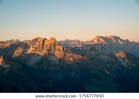 Mountain peaks in the Swiss alps in yellow sunrise light