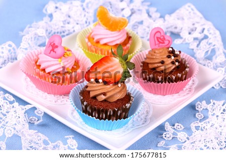 Assorted cup cakes with angel, heart, tangerine, strawberry, close up