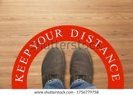 Footprint sign red color with text keep your distance, social distancingat the shop.