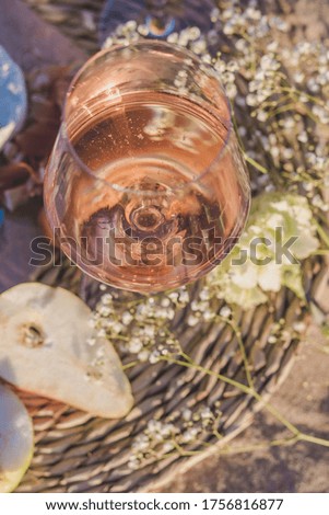 summer picnic on the coastline of sea. composition with rose wine in glasses, camamber cheese, apricots, melon, hamon and baguette. 