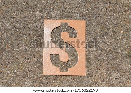 Cardboard stencil dollar sign on cement