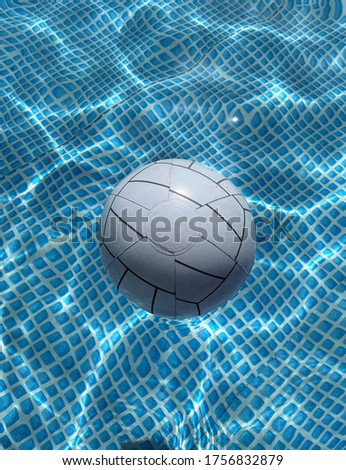 Inflatable white ball in the pool water