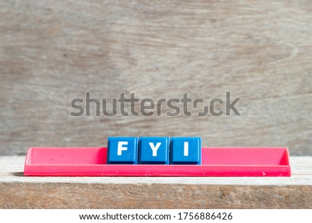 Tile letter on red rack in word FYI (Abbreviation of For your information) on wood background
