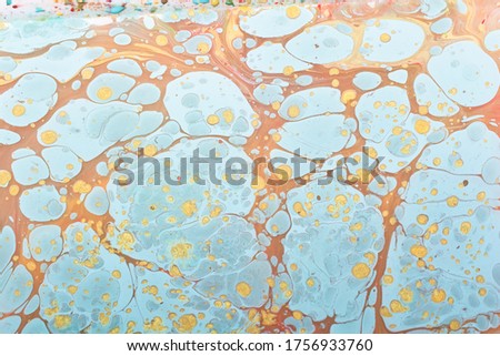 A closeup shot of an abstract painting made of blue, gold and brown colors