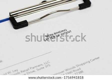 An unrecognizable person filling non-binding letter of intent. Close-up view