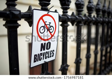 Sign indicating the prohibition to park bikes hanging on a fence in central London.