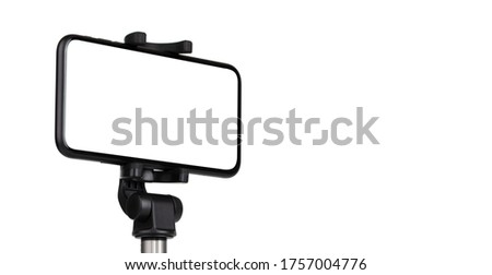 Smartphone with a white cut-out screen on a monopod. Selfie stick and smartphone on a white background.