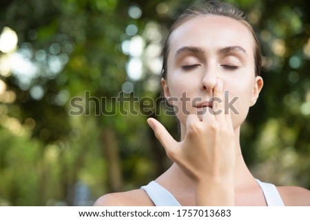 woman practicing yoga breathing technique, surya bheda pranayama, the sun breathing with one nostril Royalty-Free Stock Photo #1757013683
