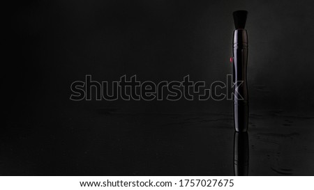 cleaning brush for photo camera on black background with reflections