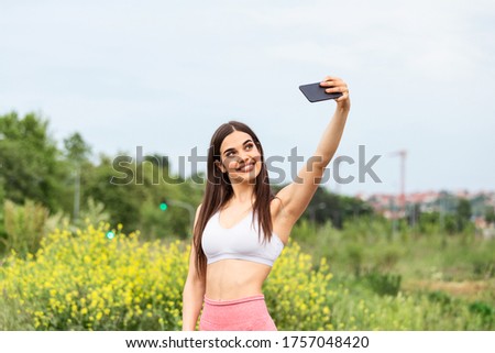 Beautiful young woman running in the city race taking a selfie, Young woman making selfie while taking fitness exercises