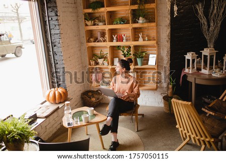 young woman seating with laptop in cafe