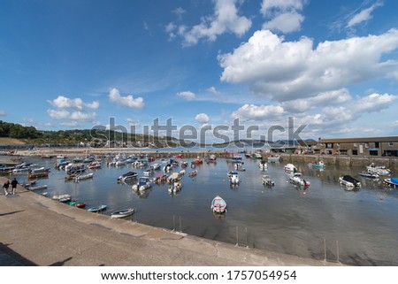 Landscape photo of boats floating in the harbour at Lyme Regis in Dorset