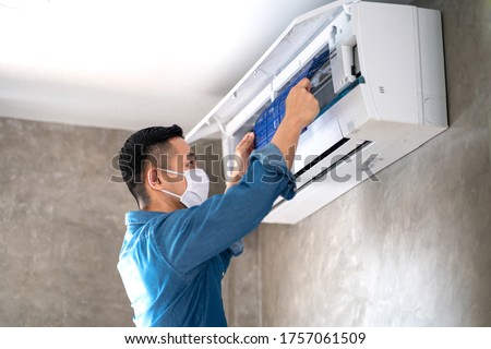 Technician man repairing ,cleaning and maintenance Air conditioner on the wall in bedroom or office room.On site home service,Business ,Industrial concept. Royalty-Free Stock Photo #1757061509