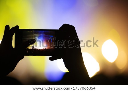 smartphone screen in the hand of a fan shooting video and photos at a concert of your favorite band. festival Blur atmosphere