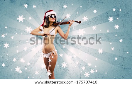 Young Santa girl in bikini playing violin