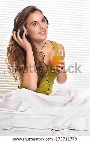 Pretty Caucasian woman in a bed with a juice