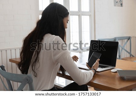 Woman sitting and holding mobile phone.