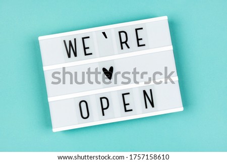 Information text WE ARE OPEN on a lightbox on a blue background. Message for customers from business. Opening of hotels, restaurants, cafes and the entertainment industry after the pandemic