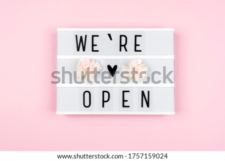 Information text WE ARE OPEN on a lightbox on a pink background. Message for customers from business.  Opening of hotels, restaurants, cafes and the entertainment industry after the pandemic