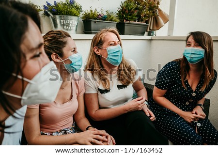 
Happy group of girlfriends meeting after the quarantine caused by the covid pandemic19. Taking caution with the use of surgical masks. New normal. Royalty-Free Stock Photo #1757163452