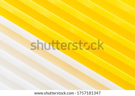 Stack of yellow and white recycled plastic containers. Duocolor background. Closeup view of containers part. Diagonal view
