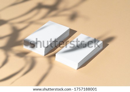 Creative photo with floral shadow of white businesscard on beige background