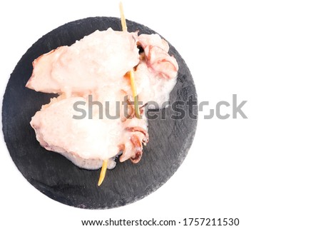 A flatlay and high key picture of "ketupat sotong" on slate plate and copyspace white background. Glutinous rice stuffed in squid that is famous East Coast of Malaysia.