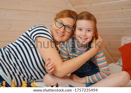 Little girl and her mom are smiling. Portrait of a daughter and mom