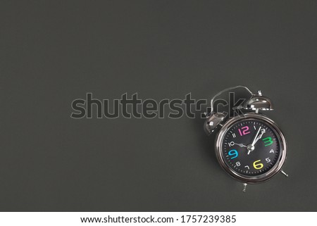 Metal antique alarm clock on black background with space for text. Back to school concept. Flat lay, Top view.