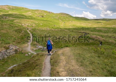 Female hker near to Potter Fell this is a fell near the villages of Burneside and Staveley, Cumbria, England. A number of tarns are present on the fell, including Gurnal Dubs Tarn and Potter Tarn. 