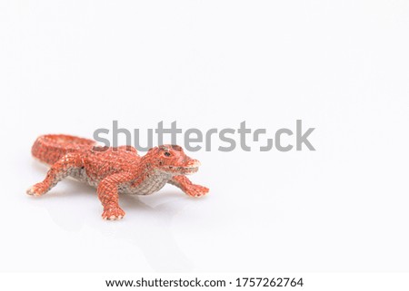 close-up of a orange plastic crocodile isolated on a white background