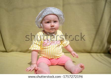 Cute baby girl wear adorable hat looking at camera make funny faces on green background