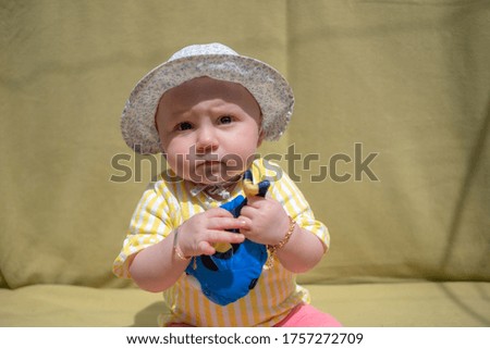 Cute baby girl wear adorable hat looking at camera make funny faces on green background