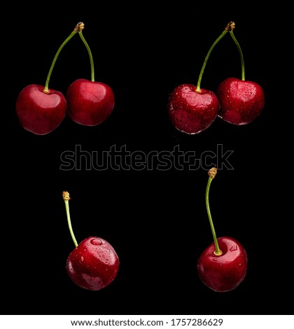 Juicy and bright cherry fruits with water drops isolated on a black background
