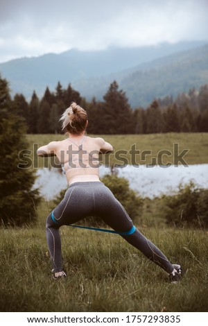 Crossfit healthy lifestyle concept. Nice chaming adorable beautiful sporty muscular fitness model lady wearing sports panties and top with blue elastic band on legs